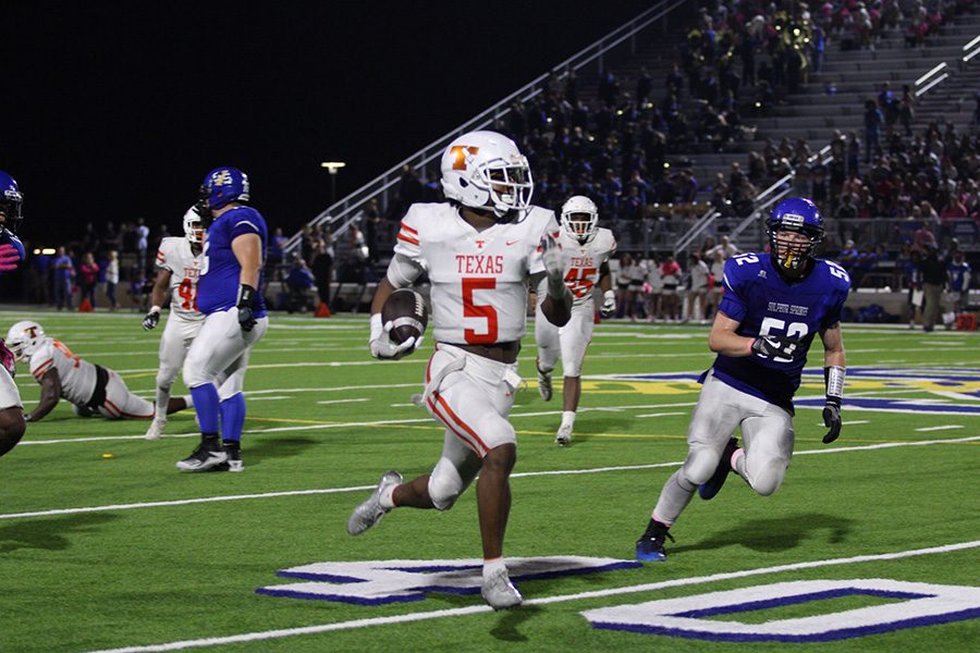 Jaylen Stewart carries the ball during a play. The Tigers won with a score of 35-21.