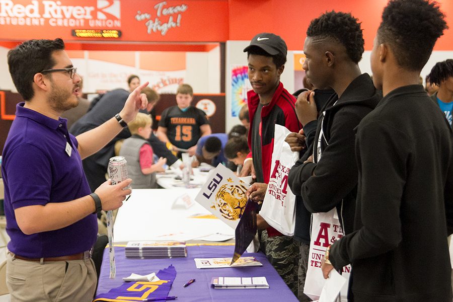 Seniors Joshua Sneed and Kenan Parker talk to Louisiana State University college recruiter during College Night. This event was open to all high school students.
