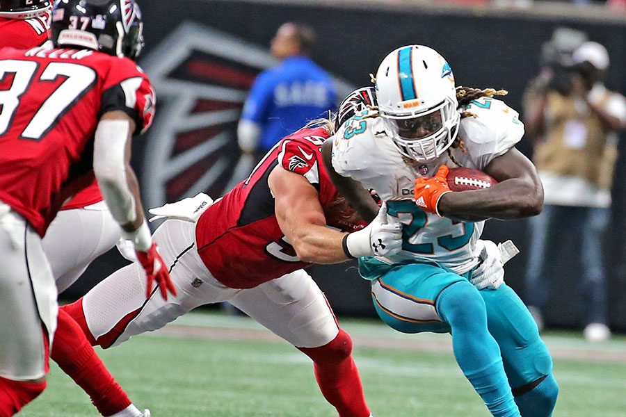 Miami Dolphins' Jay Ajayi (23) runs the ball in the fourth quarter as Atlanta Falcons' Brook Reed (50) reaches to tackle him on Sunday, Oct. 15, 2017 at the Mercedes-Benz Stadium in Atlanta, Ga. The Dolphins have traded Ajayi to the Philadelphia Eagles for a fourth-round draft pick. (Charles Trainor Jr./Miami Herald/TNS)