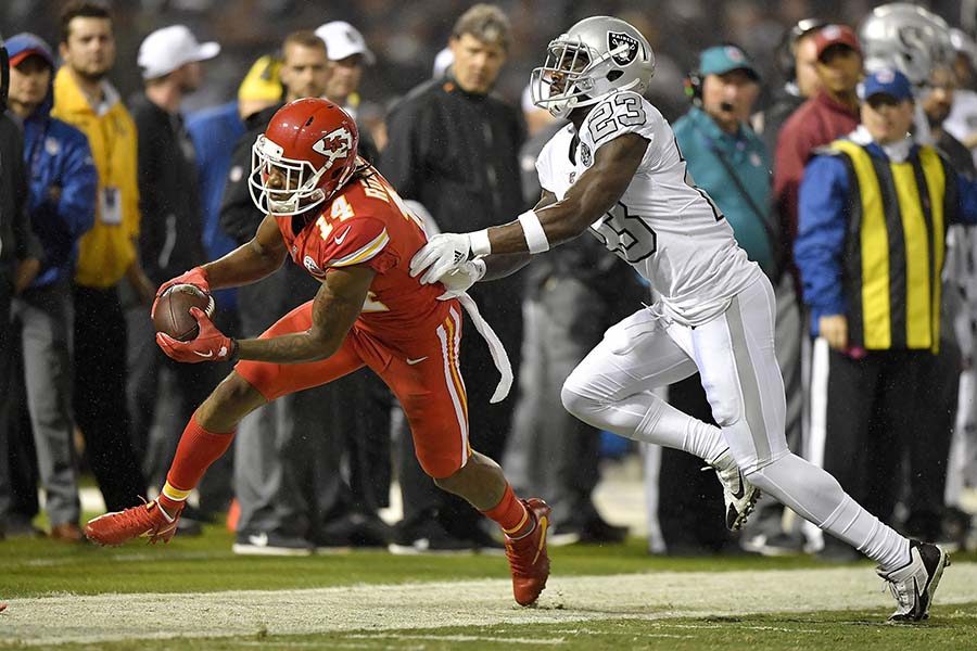 Kansas City Chiefs wide receiver Demarcus Robinson (14) picks up a first down in front of Oakland Raiders cornerback Dexter McDonald in the closing minutes of the second quarter at the Coliseum in Oakland, Calif., on Thursday, Oct. 19, 2017. (John Sleezer/Kansas City Star/TNS)