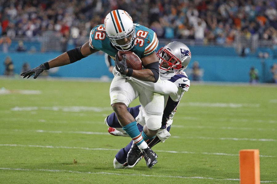 Miami Dolphins running back Kenyan Drake (32) runs towards the goal line as New England Patriots free safety Devin McCourty (32) gives chase in the second quarter as the Miami Dolphins host the New England Patriots at Hard Rock Stadium Monday, Dec. 11, 2017 in Miami Gardens, Fla. (Al Diaz/Miami Herald/TNS)