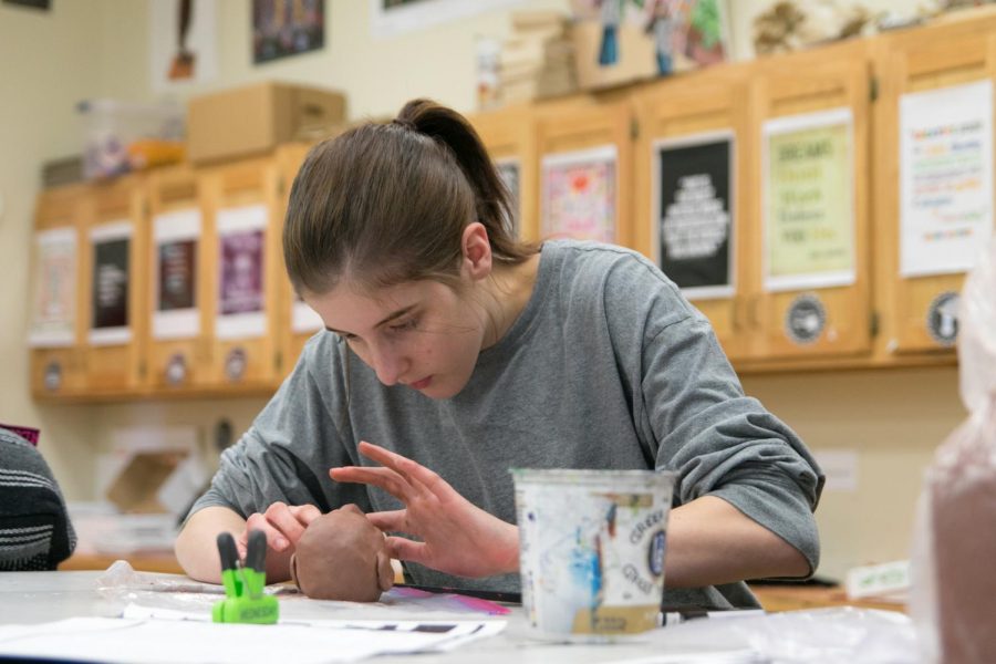 Junior McKenzie Brown morphs clay into the shape of a head with precision for an art project.