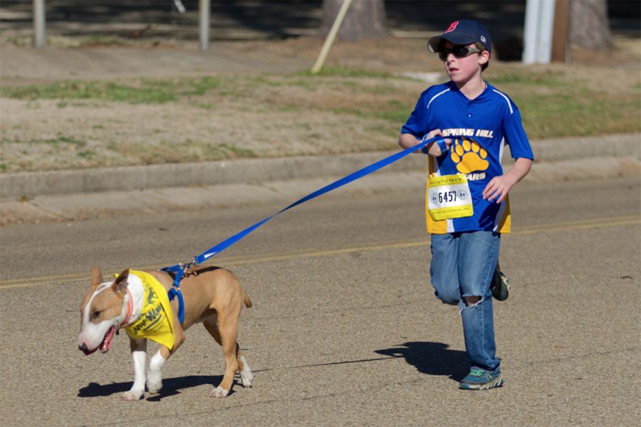 A contestant runs with his dog during the annual Six Leg Fun Run and 5K. This event was held on Jan. 28, and was intended to bring in donations for the local animal shelters.