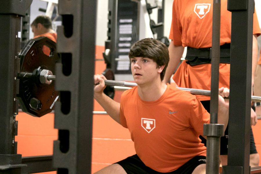 Sophomore Michael Sikorski squats with the help of his partner during his athletic period. All baseball teams are doing weight training this year as a part of their program. 