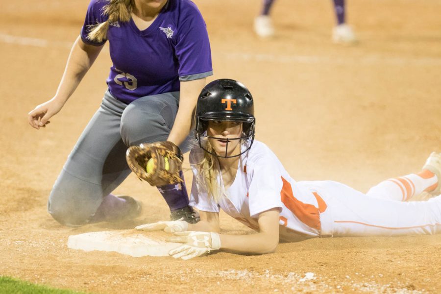 As the dust settles, senior Ryann Williams waits for the call from the umpire. Williams dove head first back to first base when the Hallsville catcher tried to throw her out. Tigers lost their home opener 9-7. 