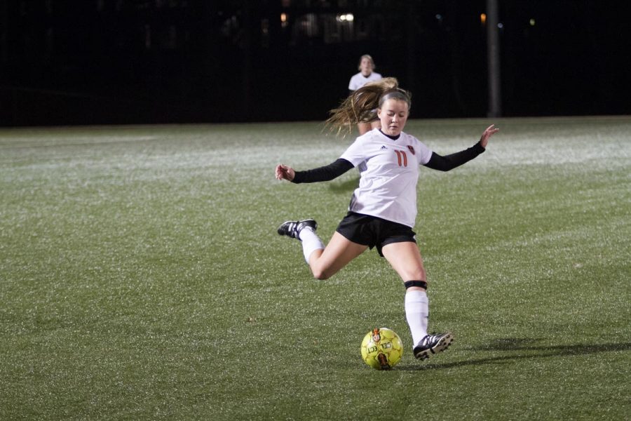 Junior Sarah Jane Paddock passes the ball in an assist to score another point against Greenville.