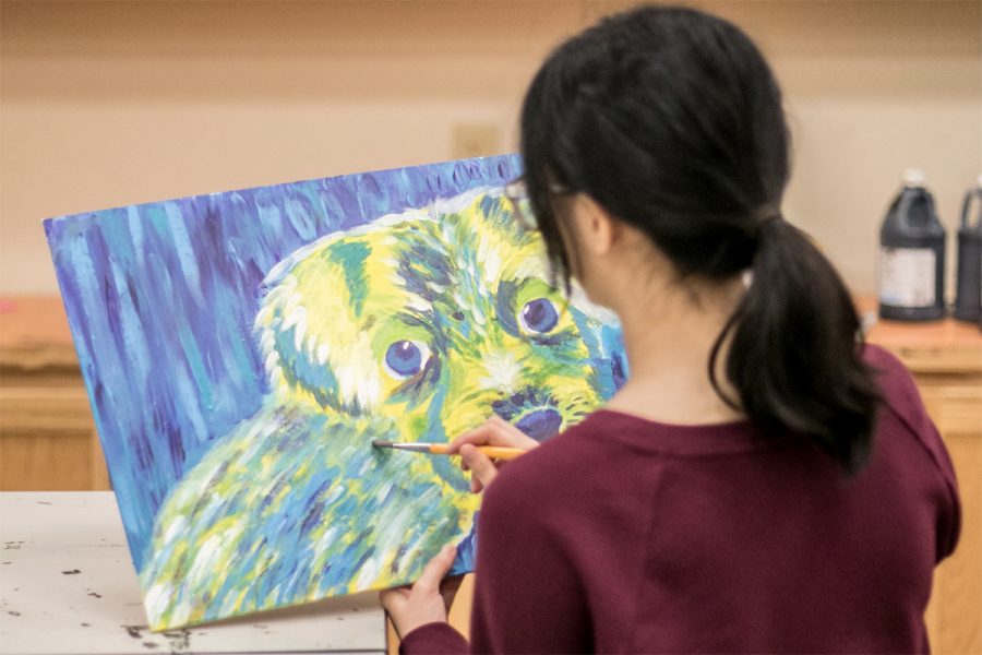 Junior Victoria Van paints a  dog in vivid colors to be donated to the local animal shelter.