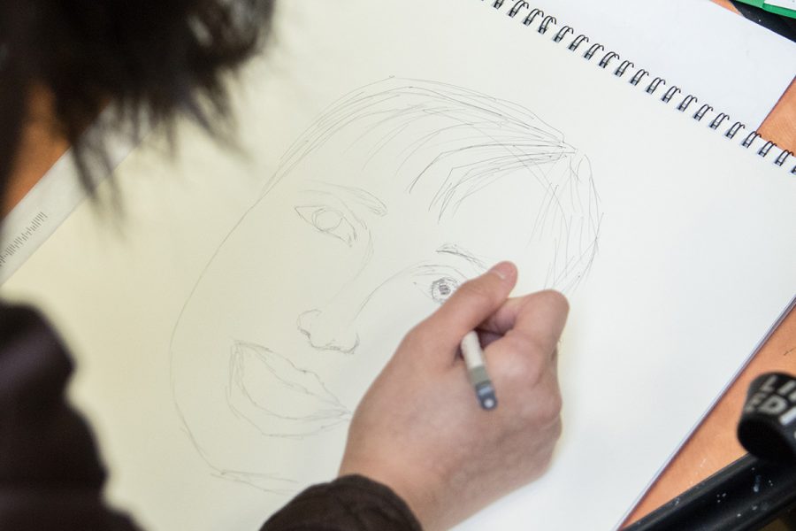 Art Club members draw portraits of children from an orphanage in Afghanistan to send back to them for the Memory Project. Portraits will be sent in May.