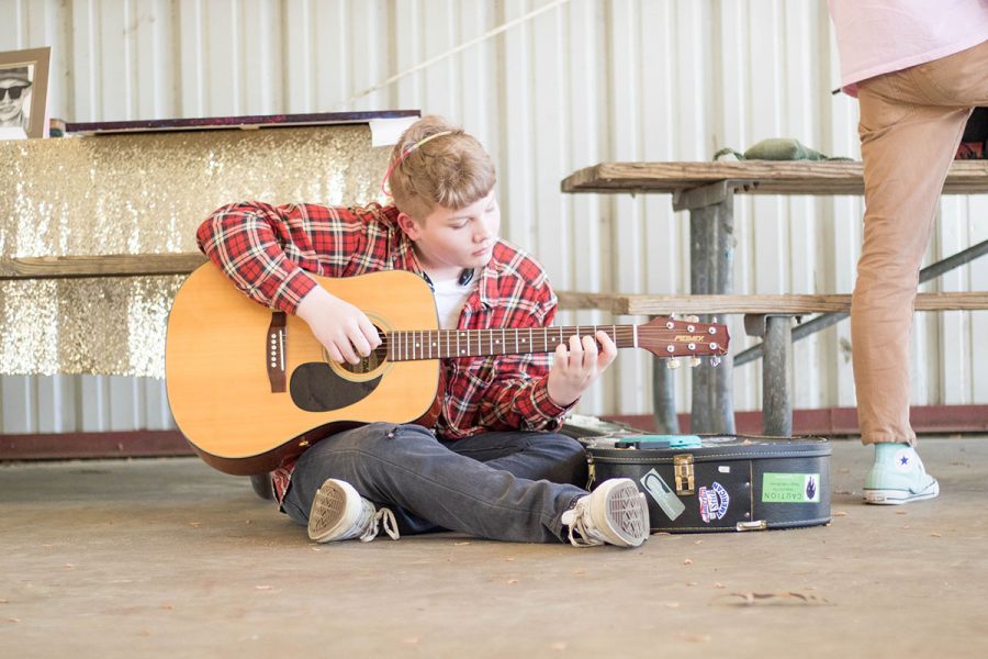 An attendee of the Equality Speaks event plays guitar on the ground of the pavilion. The event was held this past Saturday, and was meant to bolster positive representation for LGBT people.