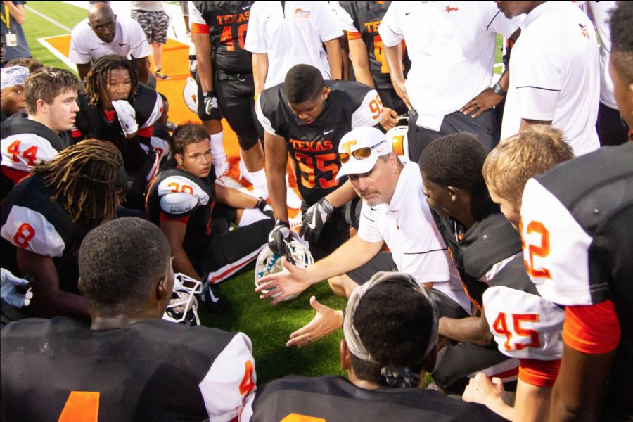 The football team huddles around one of their coaches as they take direction for the next drive. The Tigers will play Pflugerville Hendrickson in 
Waxahacie at 7 pm.