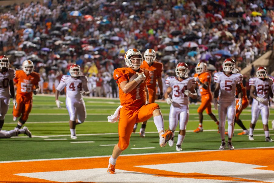 Quarterback Colton Clack high steps into the end zone with Razorbacks trailing behind him. Clack lead the Tigers in a come from behind victory against the Razorbacks. 