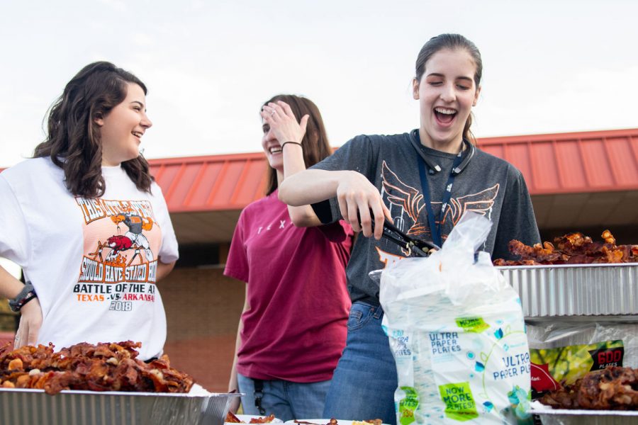 Seniors Mckenzie Brown, Sarah King and Meagan Brown help serve bacon at the annual Bacon Fry that was held on the morning of September 7th in the Texas High School courtyard.