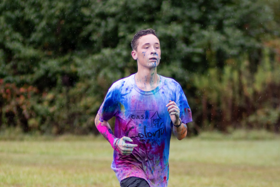 At the annual CASA color run, sophomore Caden Rainwater treks on despite the rain. 