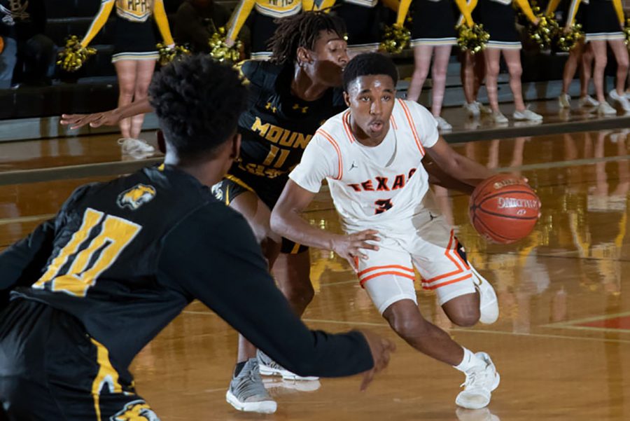 Junior Matthew Arnold dribbles down the court dodging apposing players. 