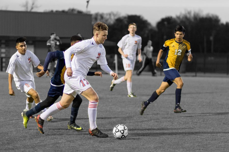 Senior John Powell dribbles through the Pine Tree defense in a district game. The boys’ team looks to overcome adversity and find some success this season.