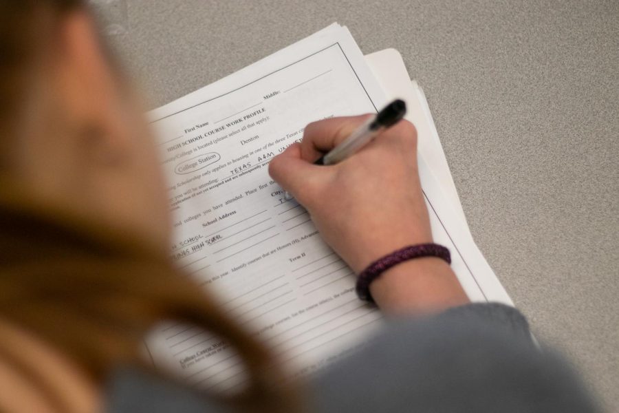 A senior fills out an application detailing the planned college of attendance. Seniors faced countless applications in the fall for scholarships and college admissions.