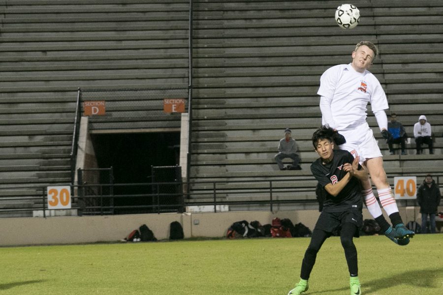 Senior John Powell goes up to win a ball against a Marshall defender in a district match. Powell looks to be a leader for the team in his final season at the helm.