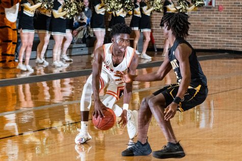 A Tiger basketball player looks to rush away from a Mount Pleasant defender. The Tigers defeated the Mount Pleasant Tigers 58-55.