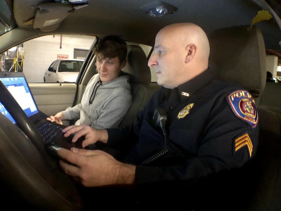 Texarkana, Arkansas Sgt. Jeremy Gordon explains to senior Garrett Burks what he does on his laptop while on patrol. The Explore Program has allowed students to learn more about law enforcement careers for over 25 years.