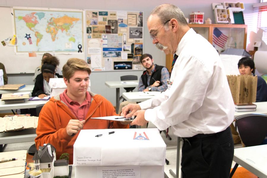 2016 graduate Cooper Zverina prepares to show government teacher John Littmann his project. Littmann assigned an annual government scavenger hunt project to his students during his teaching career. 