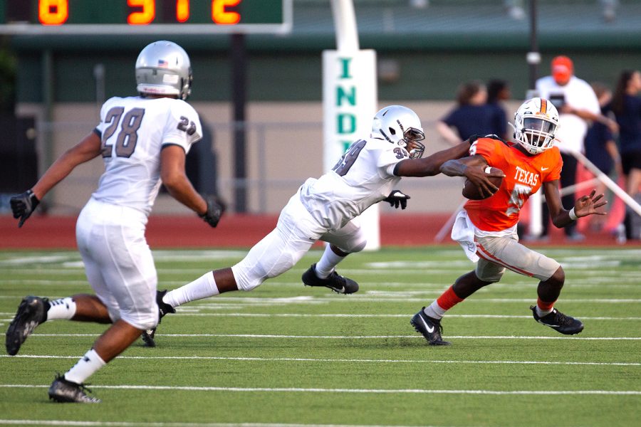 Quarterback Rian Cellers scrambles to elude Pflugerville defenders in the Texas High School vs Plugerville Henderson High School game. Due to the distance between the two schools, the teams played the game at Stuart B. Lumpkins Stadium in Waxachie, Texas on Sept. 29, 2019.