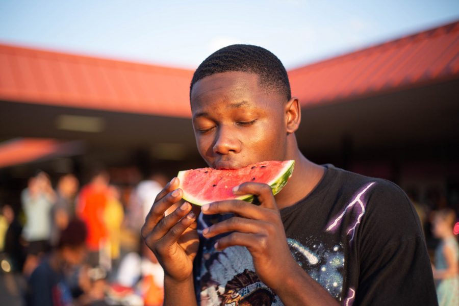 Senior+Justin+Turner+enjoys+a+slice+of+watermelon+after+the+annual+Watermelon+Supper+pep+rally.+Students+and+community+members+gathered+to+celebrate+fall+sports+and+kick+off+the+school+year.+