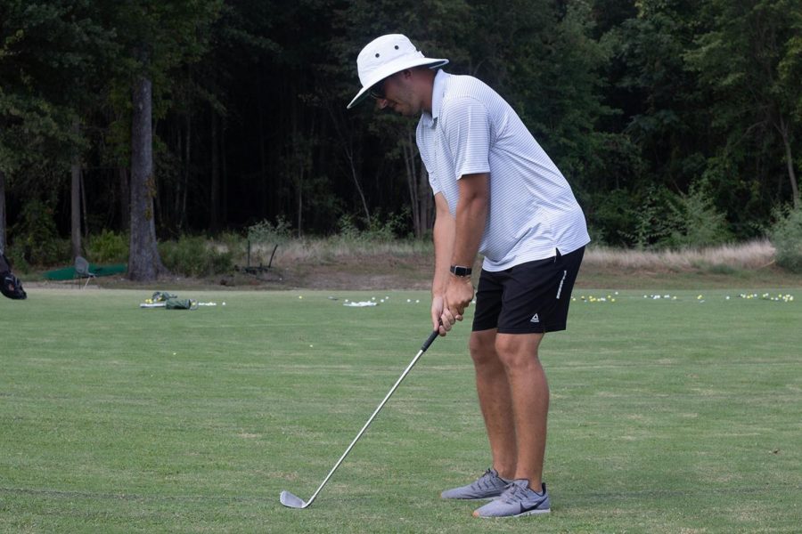 New golf coach Ryan Huntze demonstrates proper stance. Huntze previously worked as Clubhouse Manager for Northridge Country Club. 