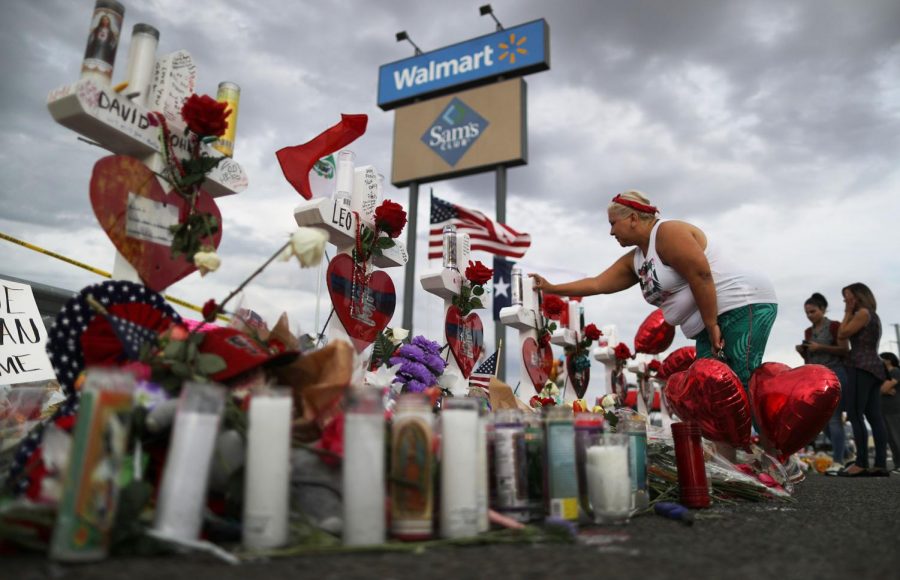 A woman touches a cross at a makeshift memorial for victims outside Walmart, near the scene of a mass shooting which left at least 22 people dead, on August 6, 2019, in El Paso, Texas. Walmart Inc. announced on Tuesday, Sept. 3, 2019m, it will phase out sales of ammunition for handguns and short-barrel rifles. (Mario Tama/Getty Images/TNS)
