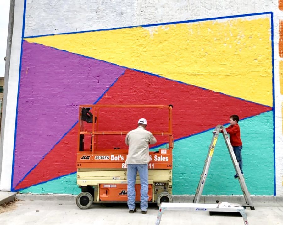 Family+members+help+add+finishing+touches+to+Danielle+Hambletts+mural.+More+murals+are+expected+to+be+painted+downtown+by+the+end+of+the+year.