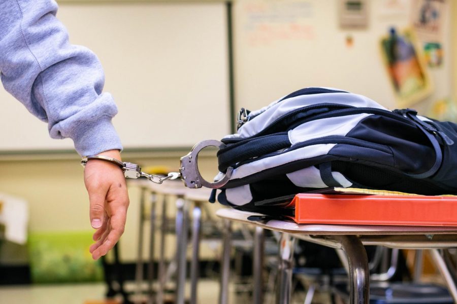 Photo Illustration. A student is handcuffed to their backpack symbolizing the restraint of homework over school breaks. 