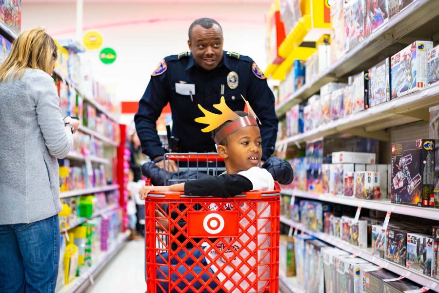 Police+officer+Alan+Bailey+shops+with+a+child+during+the+annual+Shop+with+a+Cop+and+Firefighter+event+Dec.+3+at+Target.