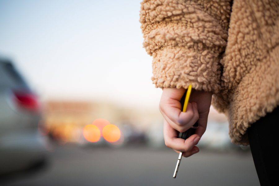 Photo illustration by Margaret Debenport. A young woman clutches her keys in a parking lot.