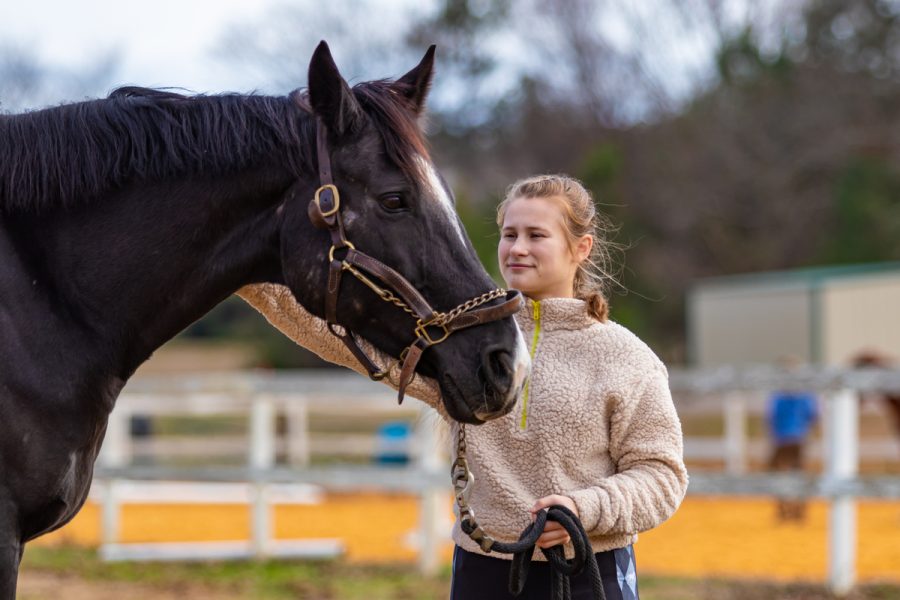 Junior Macy Sloan pets her horse, Jazz. Sloan has participated in competitive dressage events for the past four years.