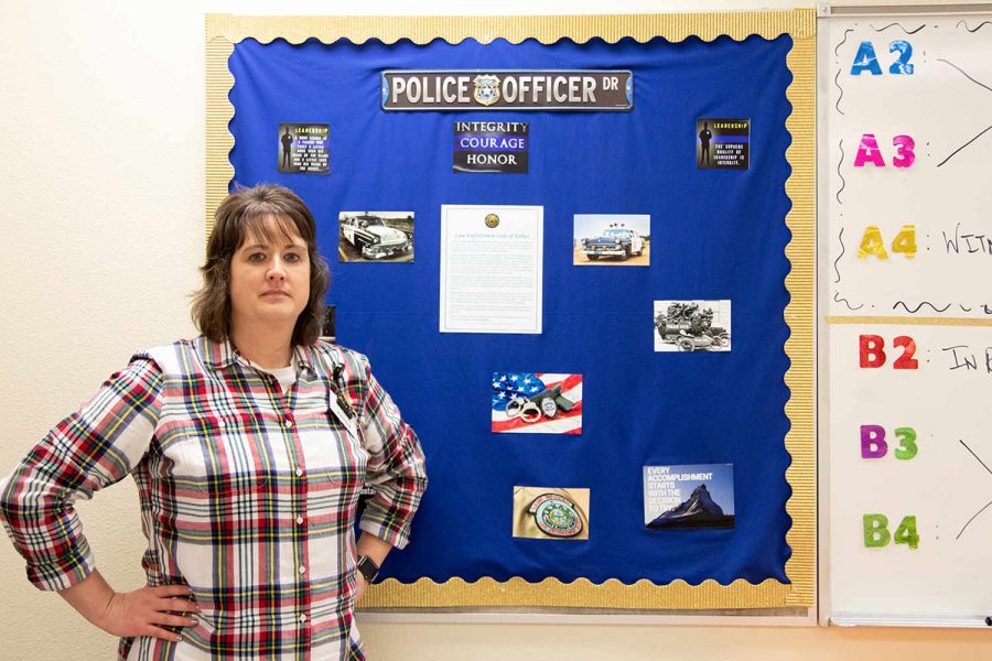 Law enforcement teacher Michelle Shannon stands against a bulletin board in her classroom. Shannon served as a law enforcement officer before becoming a teacher. 