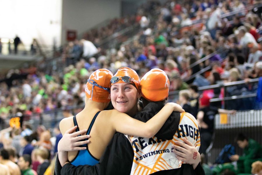 Senior Kaitlyn Rogers hugs her relay teammates as she finishes her last race as a Texas High Tigershark. The state meet was held February 15-16 in Austin, TX.