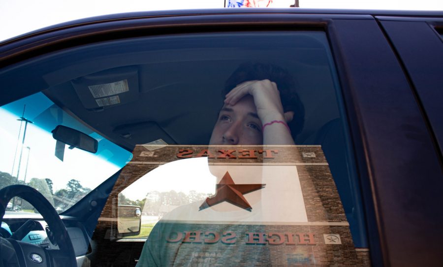 Junior Cort Rainwater sits isolated in his truck while looking out at the Texas High School Campus. Students did not return to in-person classes following spring break due to COVID-19.