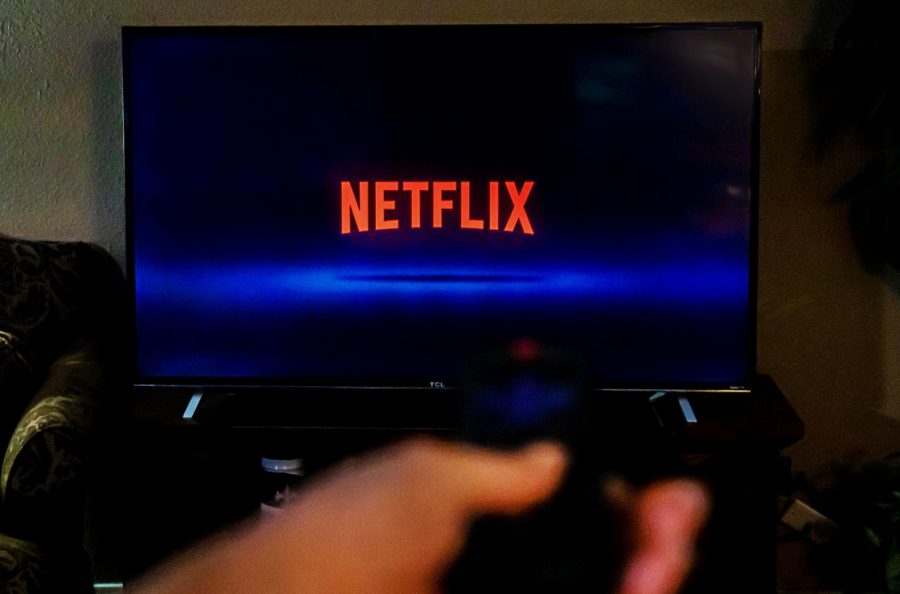 The word Netflix overtakes the television screen as a student prepares to find a show to binge. 