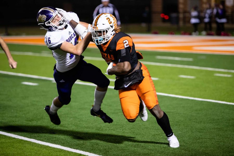 Junior Braylon Stewart stiff arms a Hallsville defender in attempt to gain yards for the Tigers. The Tigers won with a score of 56-17.