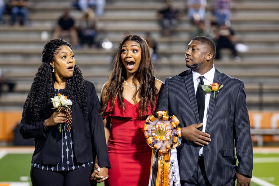 Senior Ashlyn Stiger expresses her shock after hearing her name announced as the homecoming queen. Stiger was escorted onto the field by both of her parents.