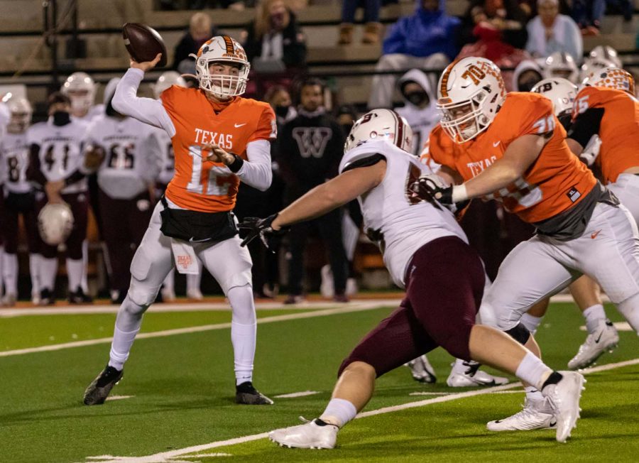 Junior Brayson McHenry passes the ball as fellow team mates defend his position. McHenry threw for multiple touchdowns in the district championship game.