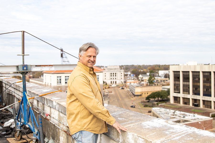 David Peavy poses while standing atop the roof of the Texarkana National Bank. The currently abandoned bank will soon be remodeled into apartment complexes. 