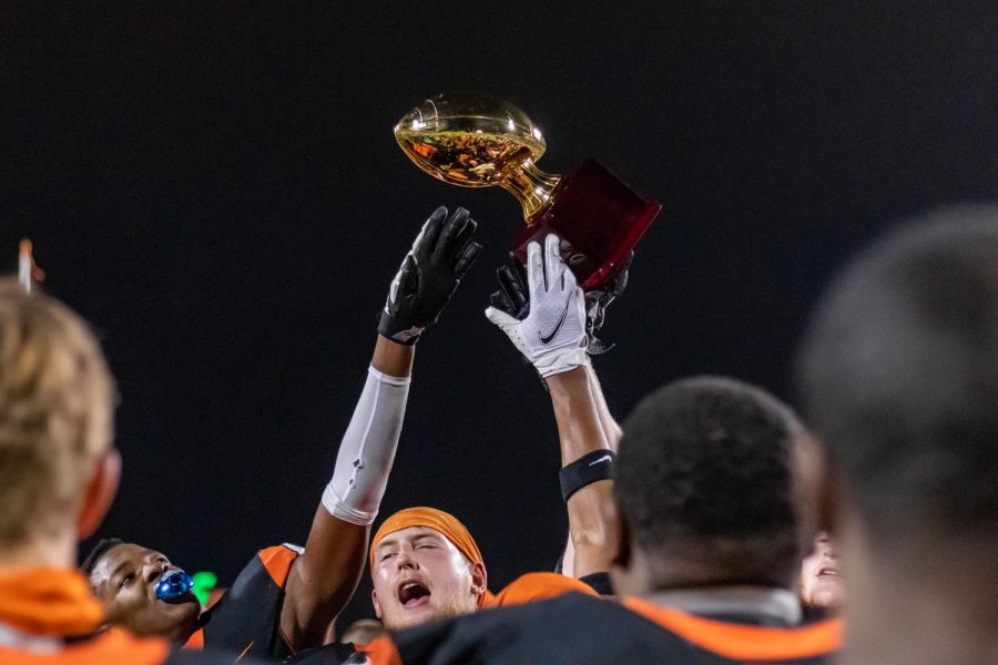 Senior Colin Shelley waves the play-offs trophy in the air after Texas High won the game against Lake Creek. The first play-offs game took place in Nacogdoches. 