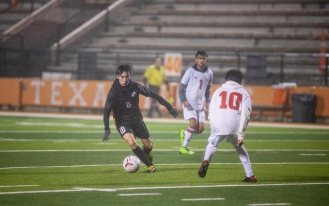  Sophomore Reece Gaylor kicks the ball away from an opposing player. Soccer players usually find themselves competing in harsh weather conditions. 