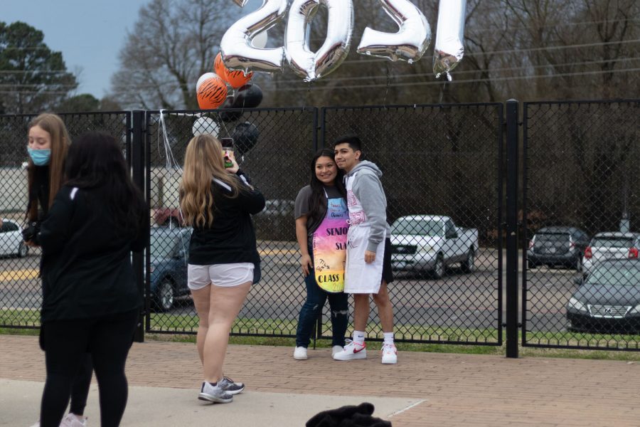 Senior Adrienne Armstrong takes a photograph of Alan Olvera and Heaven Chavez in front of the 2021 balloons. Along with music, decorations were placed around the courtyard. 