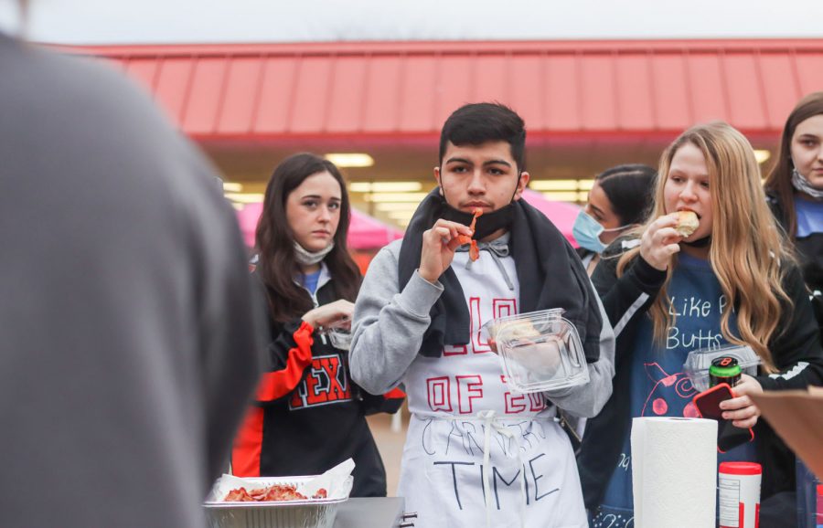 Students+eat+the+pre-prepared+meals+during+the+annual+Bacon+Fry.+The+individually+packadged+bisquits+and+bacon+were+set+out+for+seniors+to+grab+before+school.