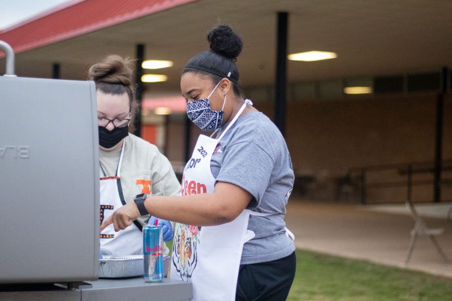 Senior, Taylor Bayonne, helps faculty cook bacon, as she enjoys bacon fry, one of her last senior memories.