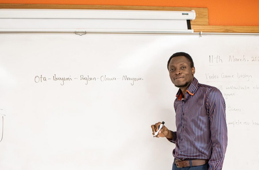 Mayowa Onare writes his name on the white board in his classroom. Despite Onares full name, he goes by Abraham.