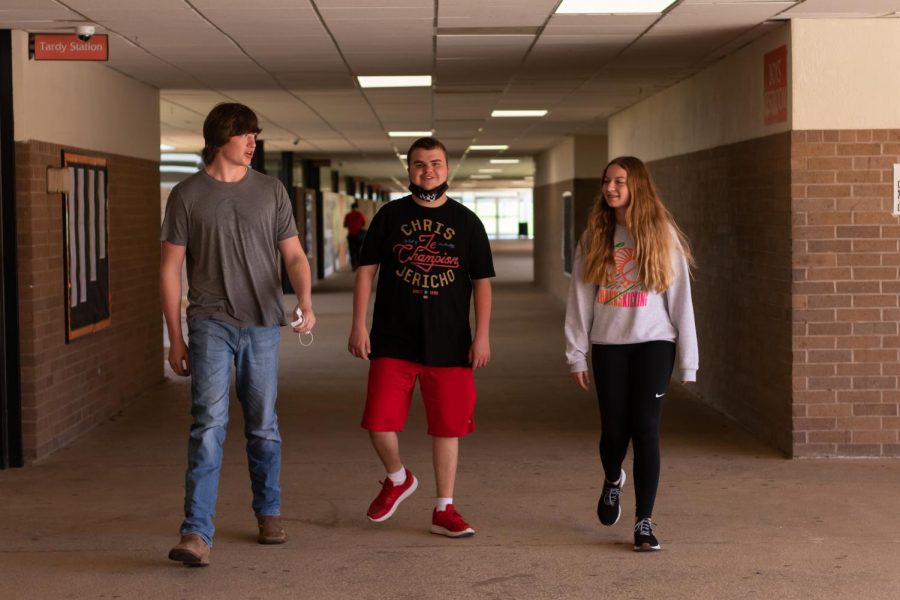 Junior Nicholas Price strolls the halls with friends, junior Thompson Matteson and freshman Annabeth Grace Killian. Although he is kind to others, Autism sometimes hinders his social skills.