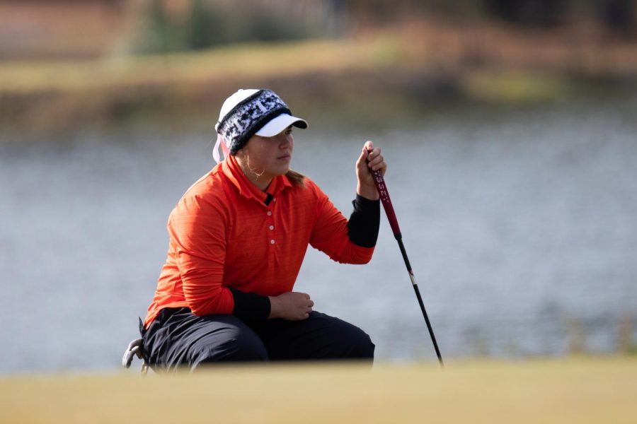 Graci Henard eyes the green as she prepares for her next putt. Throughout her high school golf career, Henard learned many valuable lessons. 