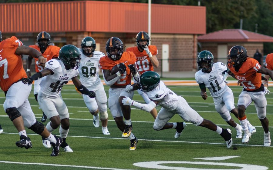 Running Back Braylon Stewart attempts to dodge the Lobos. A scrimmage was held at the Grim stadium on August 20, 2021.